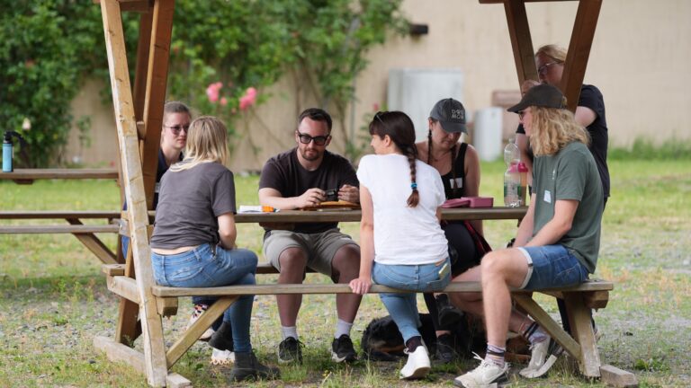 Teilnehmende sitzen beim Workshop zusammen am Tisch